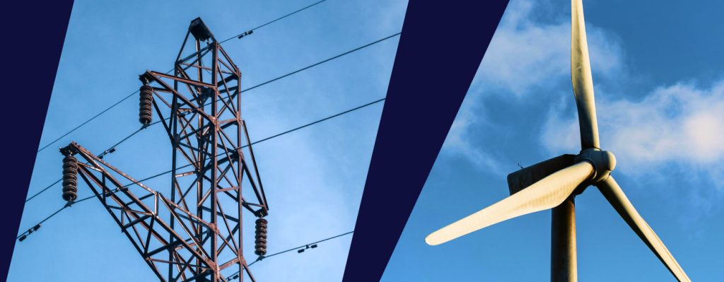 Electrical transmission tower beside a wind turbine blade, symbolizing traditional versus renewable energy infrastructure.